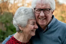 Foto. Ett äldre par som håller om varandra och ler